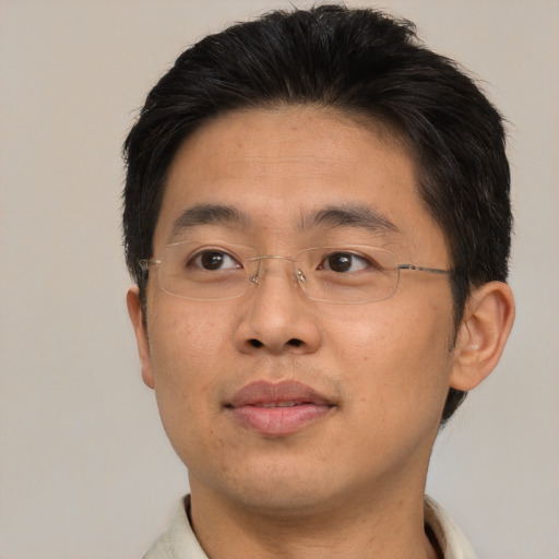 Joyful asian adult male with short  brown hair and brown eyes