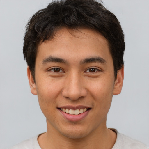Joyful asian young-adult male with short  brown hair and brown eyes