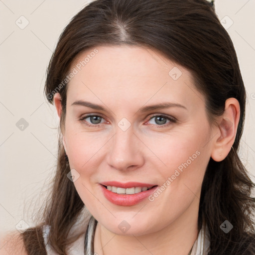 Joyful white young-adult female with long  brown hair and grey eyes