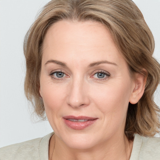 Joyful white adult female with medium  brown hair and grey eyes