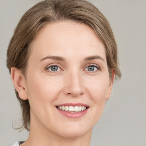 Joyful white young-adult female with medium  brown hair and green eyes