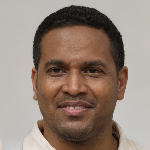 Joyful latino adult male with short  black hair and brown eyes