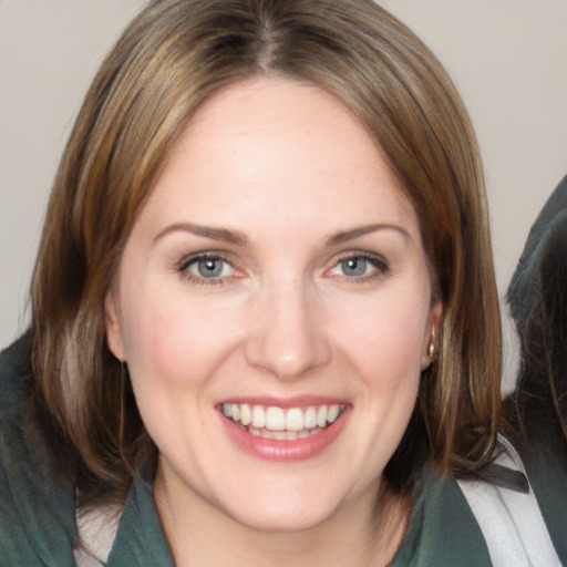 Joyful white young-adult female with medium  brown hair and blue eyes