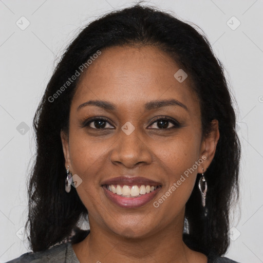 Joyful black young-adult female with long  brown hair and brown eyes