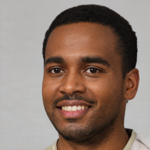 Joyful black young-adult male with short  black hair and brown eyes