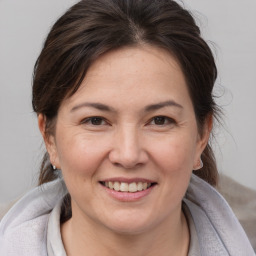 Joyful white adult female with medium  brown hair and brown eyes