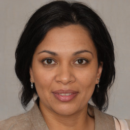 Joyful black adult female with medium  brown hair and brown eyes