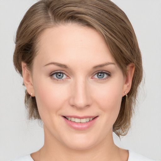 Joyful white young-adult female with medium  brown hair and grey eyes