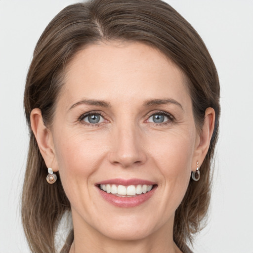 Joyful white adult female with medium  brown hair and grey eyes