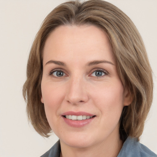 Joyful white adult female with medium  brown hair and grey eyes