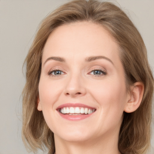 Joyful white young-adult female with long  brown hair and blue eyes