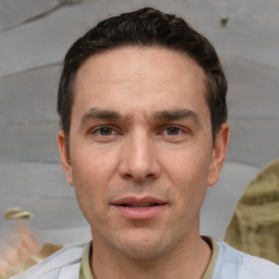 Joyful white adult male with short  black hair and brown eyes