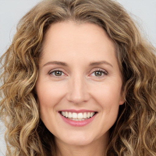 Joyful white young-adult female with long  brown hair and green eyes