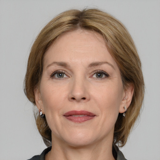 Joyful white adult female with medium  brown hair and grey eyes