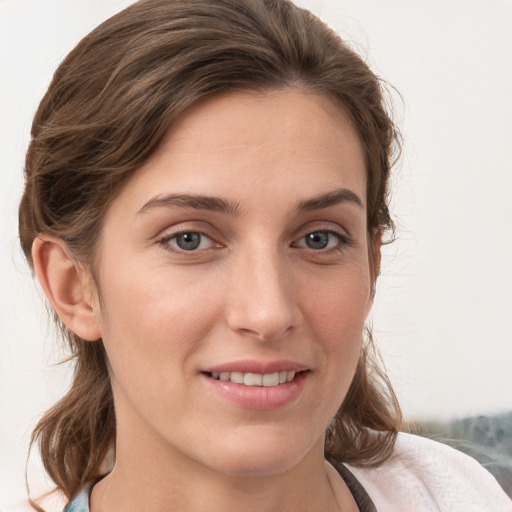 Joyful white young-adult female with medium  brown hair and grey eyes