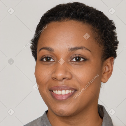 Joyful black young-adult female with short  brown hair and brown eyes