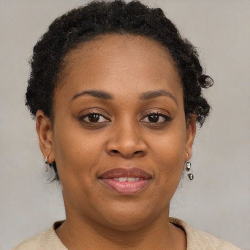 Joyful black young-adult female with short  brown hair and brown eyes