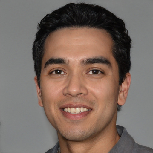 Joyful white young-adult male with short  black hair and brown eyes