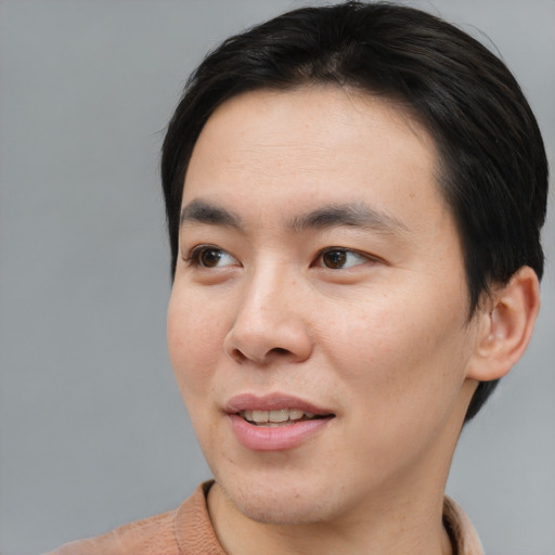 Joyful asian young-adult male with short  brown hair and brown eyes