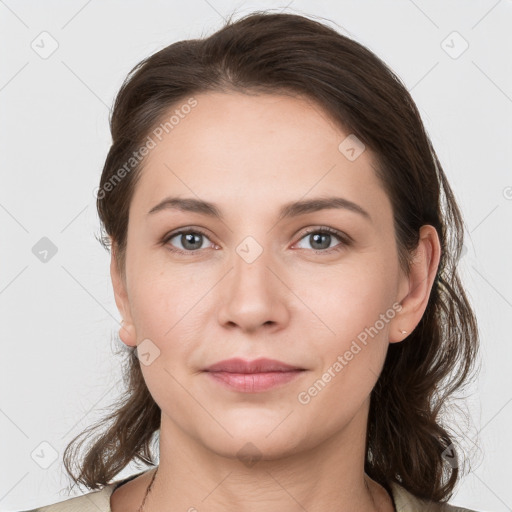 Joyful white young-adult female with medium  brown hair and grey eyes