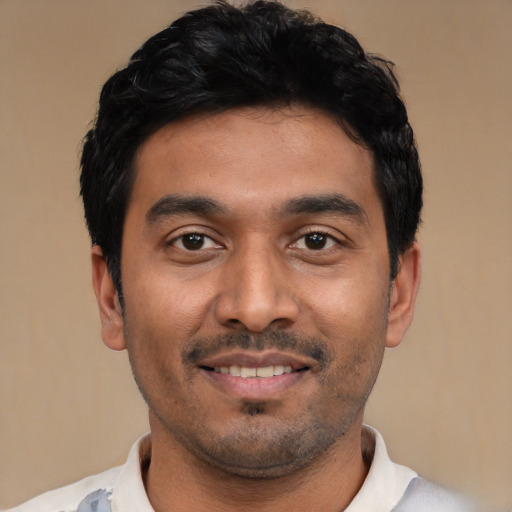 Joyful latino young-adult male with short  black hair and brown eyes