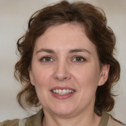 Joyful white adult female with medium  brown hair and blue eyes