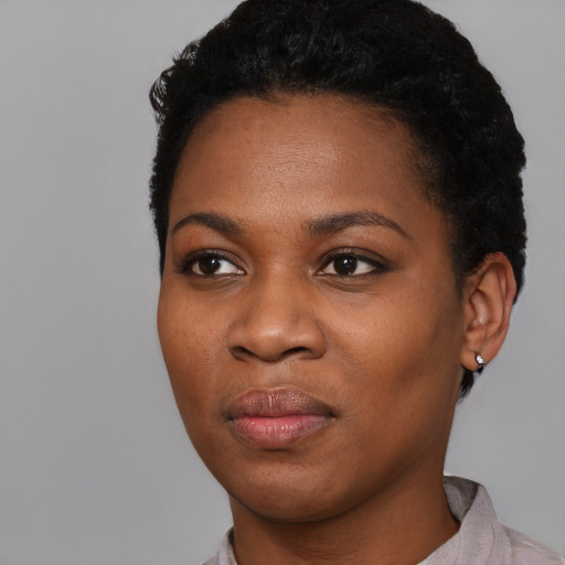 Joyful black young-adult female with short  black hair and brown eyes