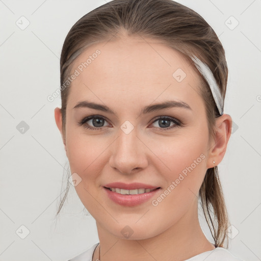 Joyful white young-adult female with medium  brown hair and grey eyes