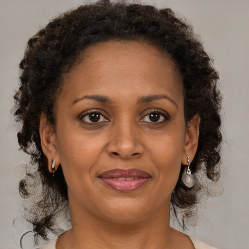 Joyful black adult female with medium  brown hair and brown eyes