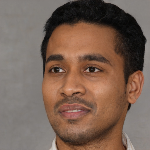 Joyful black young-adult male with short  black hair and brown eyes