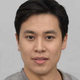 Joyful asian young-adult male with short  brown hair and brown eyes