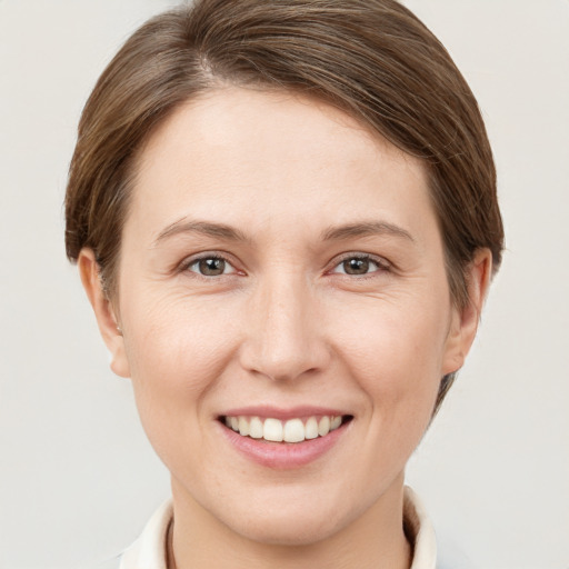 Joyful white young-adult female with short  brown hair and grey eyes