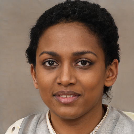 Joyful black young-adult female with short  brown hair and brown eyes