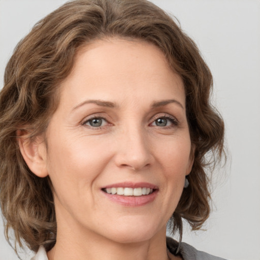 Joyful white adult female with medium  brown hair and grey eyes