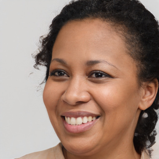 Joyful black young-adult female with medium  brown hair and brown eyes