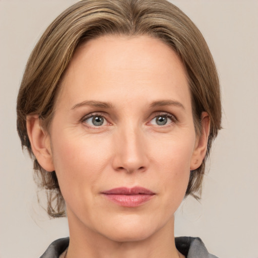 Joyful white adult female with medium  brown hair and grey eyes