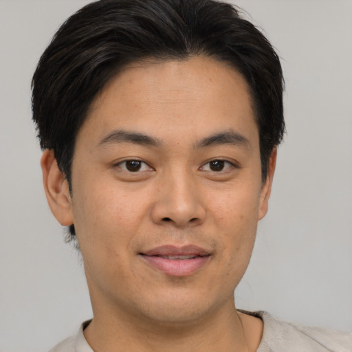 Joyful asian young-adult male with short  brown hair and brown eyes