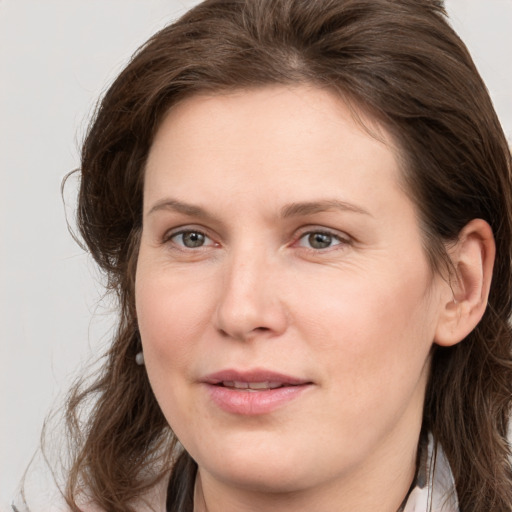 Joyful white young-adult female with medium  brown hair and grey eyes