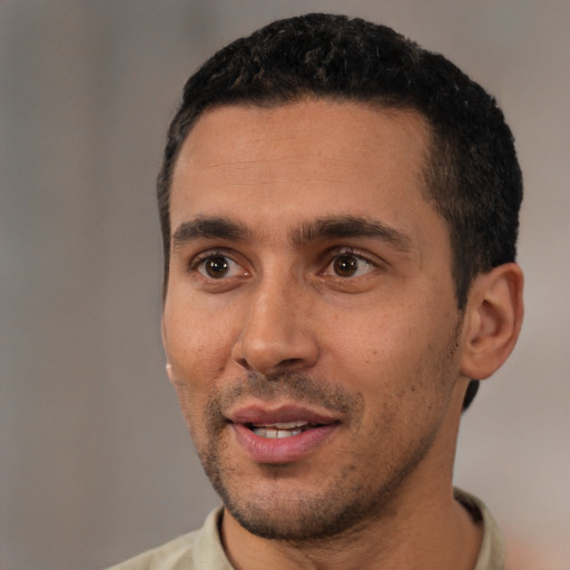 Joyful white young-adult male with short  black hair and brown eyes