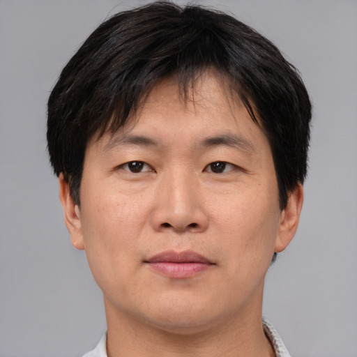 Joyful asian adult male with short  brown hair and brown eyes
