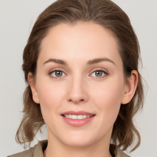 Joyful white young-adult female with medium  brown hair and grey eyes