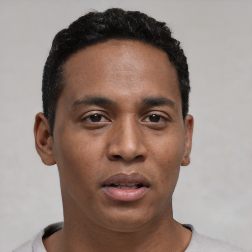 Joyful black young-adult male with short  black hair and brown eyes