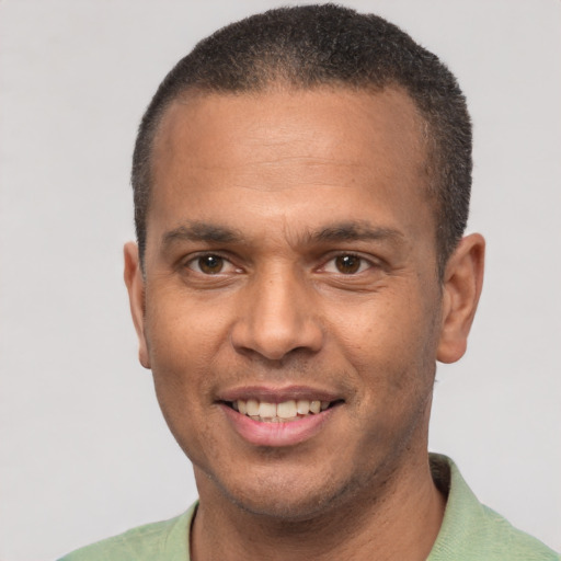 Joyful latino adult male with short  black hair and brown eyes