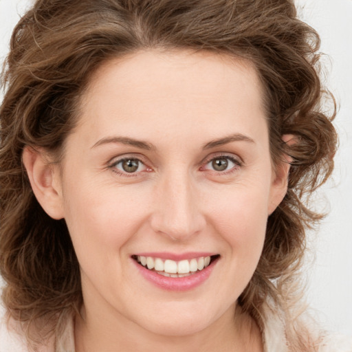 Joyful white young-adult female with long  brown hair and green eyes