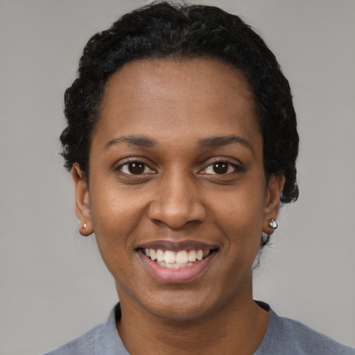 Joyful black young-adult female with short  black hair and brown eyes