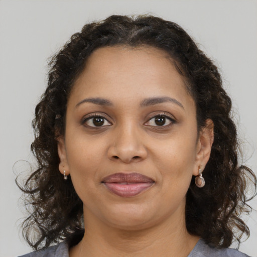 Joyful black young-adult female with medium  brown hair and brown eyes