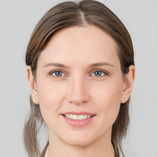 Joyful white young-adult female with medium  brown hair and grey eyes