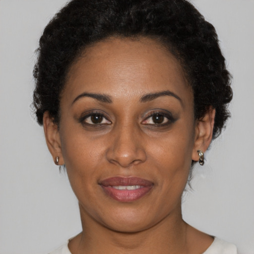 Joyful black young-adult female with short  brown hair and brown eyes
