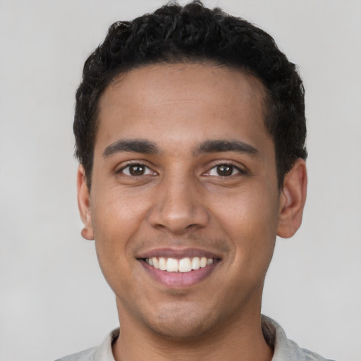 Joyful latino young-adult male with short  black hair and brown eyes