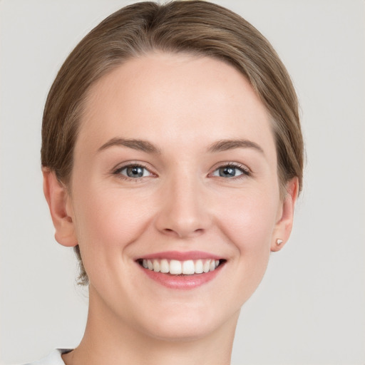 Joyful white young-adult female with short  brown hair and grey eyes